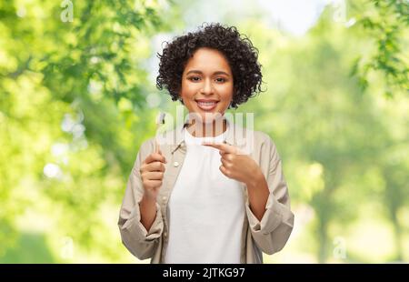 smiling woman holding wooden toothbrush Stock Photo