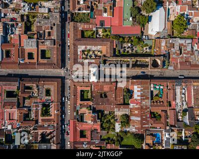 Beautiful aerial cinematic footage of the Antigua City in Guatemala, Its yellow church, the Santa Catalina Arch and the Acatenango Volcano Stock Photo