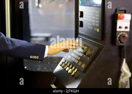 Engineer working with control panel of CNC machine. Selective focus. Stock Photo
