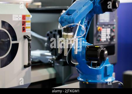 Industrial collaborative robot and CNC lathe machine. Selective focus. Stock Photo