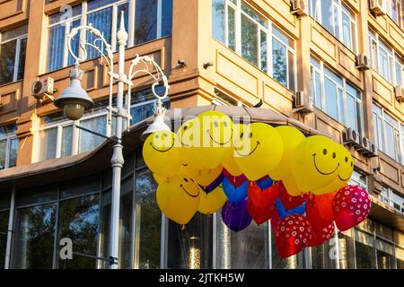yellow balloons emoticons. a bunch of balloons in the city Stock Photo