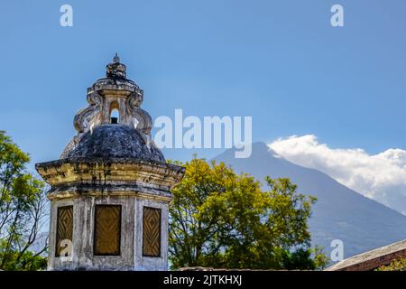 Beautiful aerial cinematic footage of the Antigua City in Guatemala, Its yellow church, the Santa Catalina Arch and the Acatenango Volcano Stock Photo