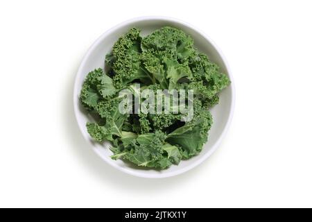 Chopped kale in a white bowl, shot from above isolated on white with clipping path cut out Stock Photo