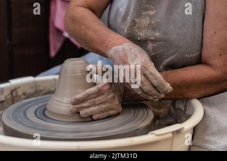 hands working a piece of clay on the potter's wheel Stock Photo