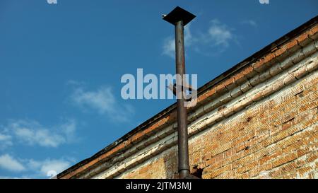 Pipe on house. Details of building. Industrial pipe from furnace. Brick house. Stock Photo