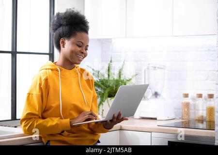 Happy attractive african american girl working office work remotely from home Black woman using laptop computer Distance learning online education and Stock Photo