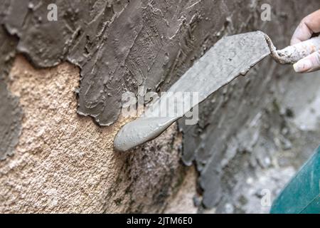 woman with bucket pouring cement on a wall in Rio de Janeiro Brazil. Stock Photo