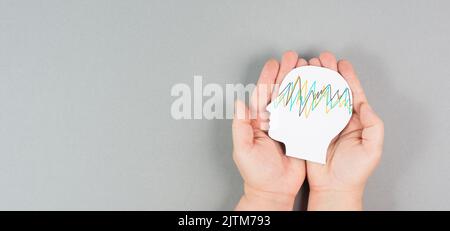 Holding a head in the hands, epilepsy disorder awareness, brain waves,mental health care, paper cut out Stock Photo