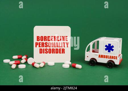 Medical concept. On a green surface, an ambulance, pills and a sign with the inscription - Borderline Personality Disorder Stock Photo