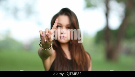 Annoyed attracrtive woman rejecting with hand and finger telling viewer NO, defending stand Stock Photo