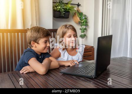 Kids in front of the computer surfing the Internet. The use of new technologies to study and learn Stock Photo