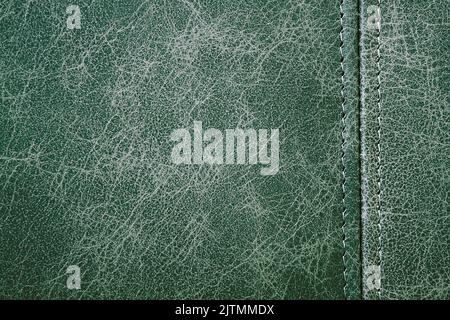 Texture green leather with a vertical seam, closeup background Stock Photo
