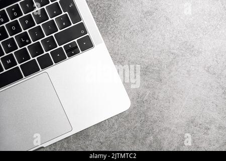 Laptop notebook keyboard on grey background. Office workspace flat lay Stock Photo