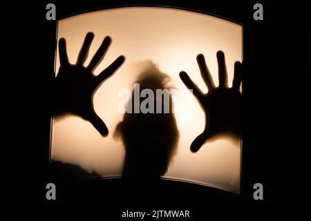 scary picture of hands behind glass, horror ghost behind door, Halloween  concept Stock Photo