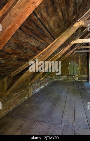 Wooden floor, beams and roof boards with stacked pink fiberglass ...