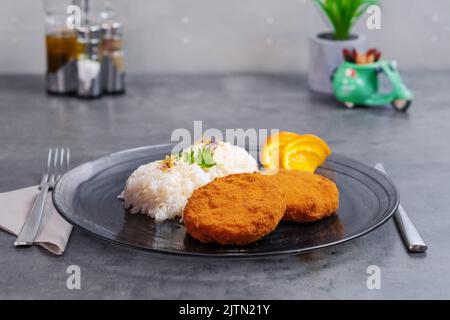 fried camembert cheese with steamed rice and orange slices in the hotel  Stock Photo