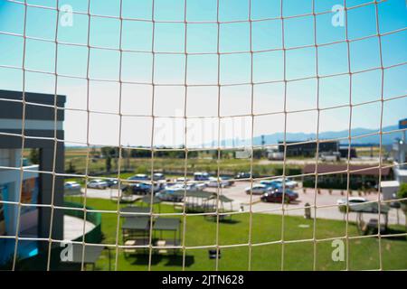 The city behind the mesh , the net, the macro City view between rusty iron mesh bars Stock Photo