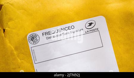 Orleans, France - Oct 18, 2014: Close-up macro shot of Frequenceo distribution without signature sticker issued by La Poste french operator on the yellow envelope Stock Photo