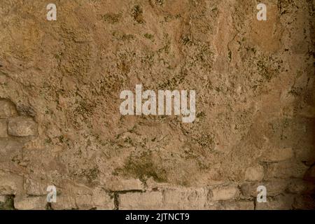 Detail of partly plastered crumbled brick well visible textured wall of yellow bricks to use as background Stock Photo