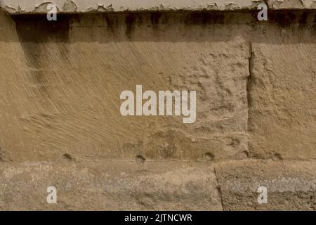 Detail close up of sandstone blocks of historical old antique wall with set back structured facade to use as background Stock Photo