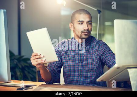 Dont look at the time, just get the job done. a young designer working late in an office. Stock Photo