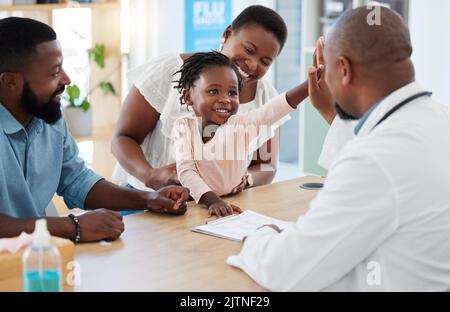 High five, doctor and family with a girl and her parents at the hospital for consulting, appointment and healthcare. Medicine, trust and support in a Stock Photo