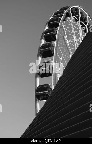 Millennium wheel on Chicago's Navy Pier emerges behind a ventilator opening against a clear winter sky Stock Photo