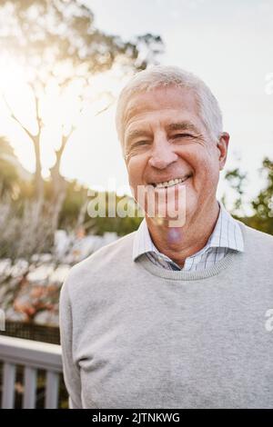 Theres a lot to smile about. Portrait of a happy senior man standing outside. Stock Photo