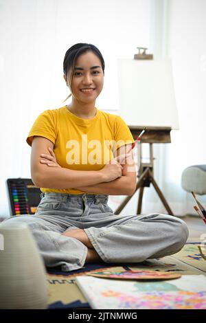Talented and professional Asian female painter or artist standing in ...
