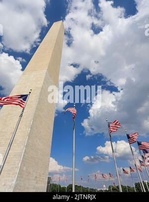 Washington Monument with American flags waving and US Capitol on the background in District of Columbia Stock Photo