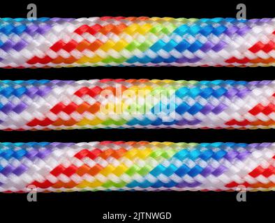 Three rainbow colored braided cotton cords isolated on black background. Stock Photo