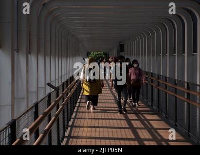 Jakarta, Indonesia-May 27, 2022: Asian people walking on the pedestrian bridge Stock Photo