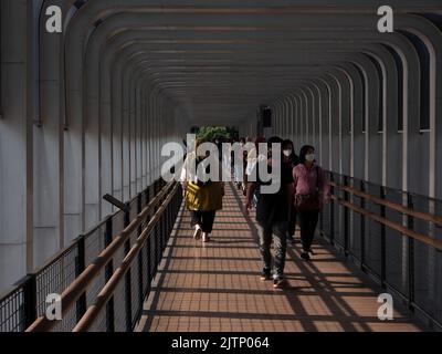 Jakarta, Indonesia-May 27, 2022: Asian people walking on the pedestrian bridge Stock Photo