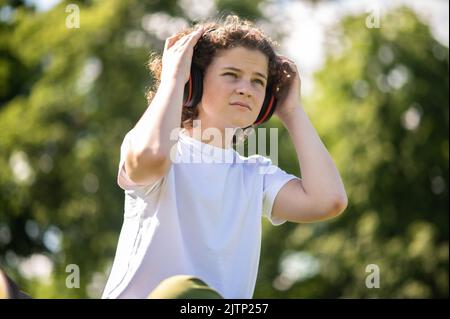 Contemporary adolescent boy relaxing alone in nature Stock Photo