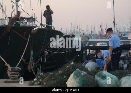 DONGYING, CHINA - SEPTEMBER 1, 2022 - Policemen learn about the production situation of fishermen preparing for sailing in Dongying city, Shandong pro Stock Photo