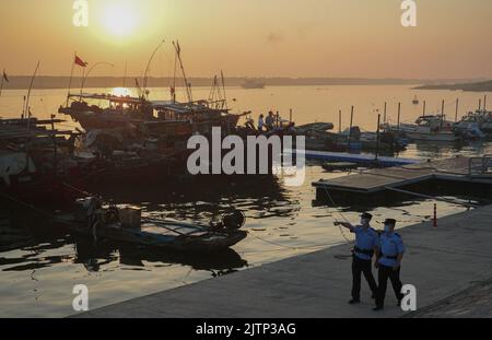 DONGYING, CHINA - SEPTEMBER 1, 2022 - Policemen patrol a dock in the early morning in Dongying city, Shandong province, China, Sept 1, 2022. Stock Photo