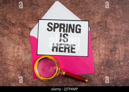 Conceptual caption Spring Is Here, Business concept After winter season has arrived Enjoy nature flowers sun Important Idea Shown On Note On Desk With Stock Photo