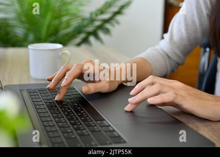 A businesswoman or female college student using notebook laptop, typing on keyboard, searching an online information or doing online homework. cropped Stock Photo