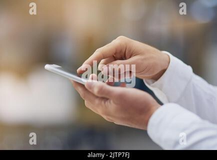 Doing business via his cellphone. an unrecognizable businessman using his cellphone. Stock Photo
