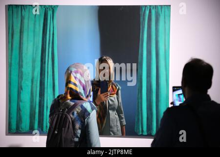 Tehran, Tehran, Iran. 30th Aug, 2022. Iranian visitors look at conceptual artwork by the Italian painter, action and object artist, and art theorist, Michelangelo Pistoletto, during the ''Minimalism and Conceptual Art'' exhibition, which showcases works from the 19th and 20th centuries by American and European artists, at the Tehran Museum of Contemporary Art in the Iranian capital on August 30, 2022. More than 20,000 people have flocked to an Iranian museum showcasing dozens of renowned Western artists' works, some for the first time -- part of a treasure trove amassed before the Islamic Rev Stock Photo