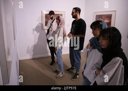 Tehran, Tehran, Iran. 30th Aug, 2022. Iranian visitors look at conceptual artworks while visiting, the ''Minimalism and Conceptual Art'' exhibition, which showcases works from the 19th and 20th centuries by American and European artists, at the Tehran Museum of Contemporary Art in the Iranian capital on August 30, 2022. More than 20,000 people have flocked to an Iranian museum showcasing dozens of renowned Western artists' works, some for the first time -- part of a treasure trove amassed before the Islamic Revolution. The museum's collection is reputed to be the greatest line-up of modern ma Stock Photo