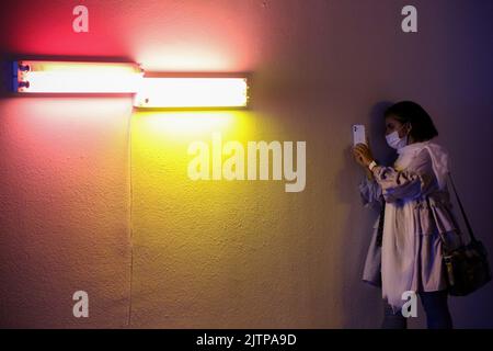 Tehran, Tehran, Iran. 30th Aug, 2022. Iranian visitors look at an installation by American artist Dan Flavin, during the ''Minimalism and Conceptual Art'' exhibition, which showcases works from the 19th and 20th centuries by American and European artists, at the Tehran Museum of Contemporary Art in the Iranian capital on August 30, 2022. More than 20,000 people have flocked to an Iranian museum showcasing dozens of renowned Western artists' works, some for the first time -- part of a treasure trove amassed before the Islamic Revolution. The museum's collection is reputed to be the greatest li Stock Photo