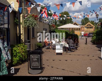 Customers enjoying afternoon tea at Miss Havisham's Tearoom, a traditional cafe, set in a quaint courtyard off the High Street, Stony Stratford, UK Stock Photo