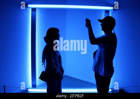 Tehran, Tehran, Iran. 30th Aug, 2022. Iranian visitors look at an installation by American artist Dan Flavin, during the ''Minimalism and Conceptual Art'' exhibition, which showcases works from the 19th and 20th centuries by American and European artists, at the Tehran Museum of Contemporary Art in the Iranian capital on August 30, 2022. More than 20,000 people have flocked to an Iranian museum showcasing dozens of renowned Western artists' works, some for the first time -- part of a treasure trove amassed before the Islamic Revolution. The museum's collection is reputed to be the greatest li Stock Photo