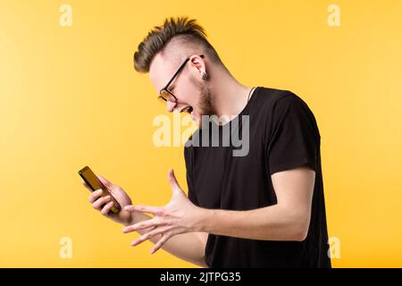 wtf young man screaming smartphone grimacing Stock Photo