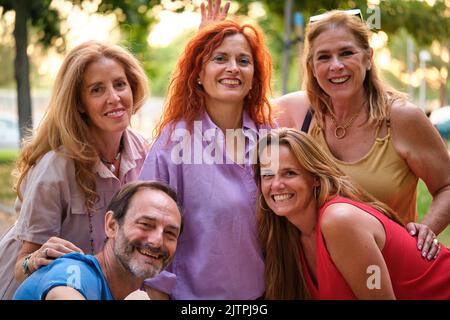 Five mature adults taking a selfie and having fun in a park. Stock Photo