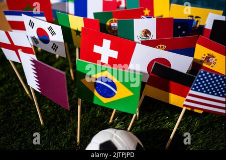 Football Wallpaper. Ball and national lags of top world soccer countries. Wallpaper for Tournament in Qatar Stock Photo