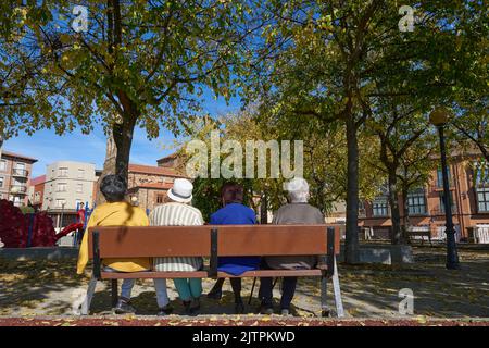 Four older ladies sitting on a park bench in Astorga Stock Photo - Alamy