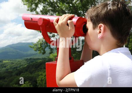 Kid examines Azish-Tau ridge through binoculars, Adygea Stock Photo