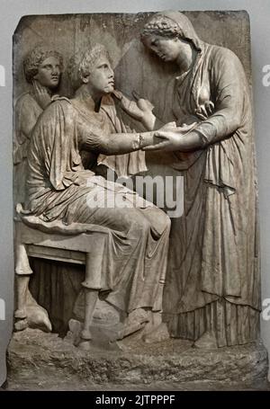 Funerary Stele of Farewell 4th cent. B.C. National Archaeological Museum in Athens,  Found, Omonoia Square, Athens. A woman seating on a stool extends her right hand to a standing relative, who holds it tenderly at the wrist and raises her other hand in a gesture of speech, At the left stands a girl lost in reflection. A small partridge pecks at the ground beneath the dead woman’s seat, Stock Photo